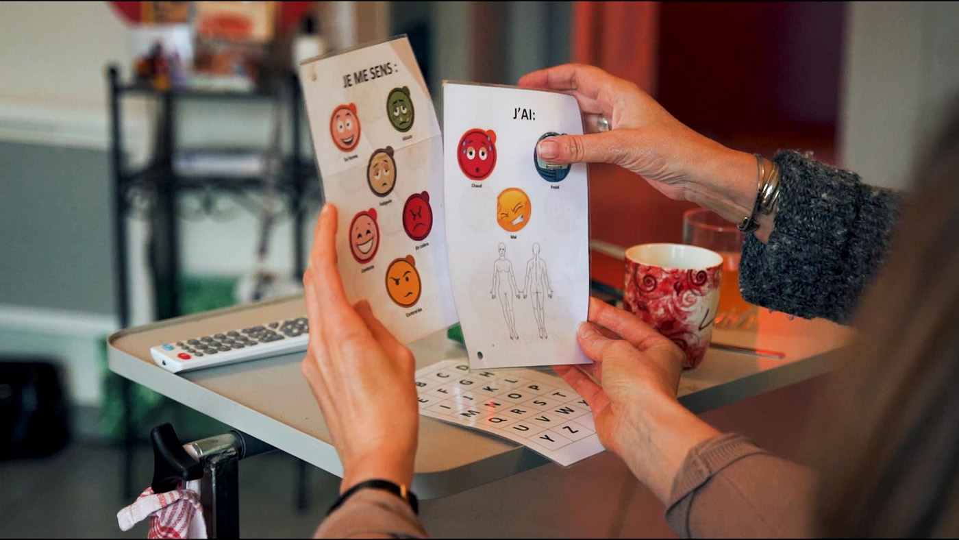 Person holding emotion communication booklet at table