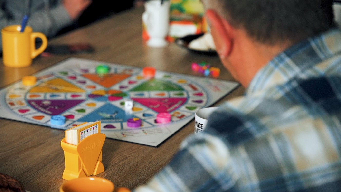 Friends playing colorful board game at table